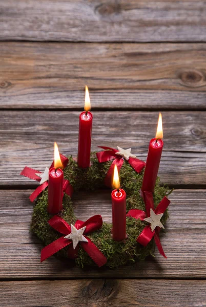 Quatro velas de advento em chamas vermelhas no fundo de madeira para o cristo — Fotografia de Stock