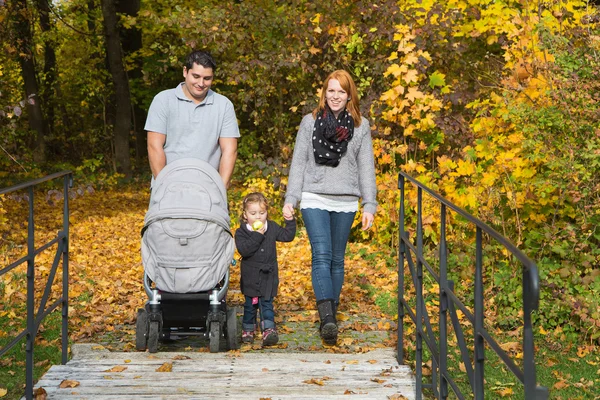 Happy young family in autumn making together a walking tour. — Stock Photo, Image