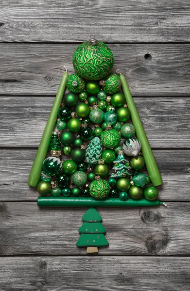 Grüne Weihnachtsbaum von Kugeln auf Holz Hintergrund dekoriert. — Stockfoto