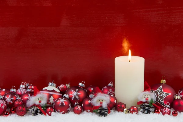 Röd trä jul bakgrund med ett brinnande ljus i advent. — Stockfoto