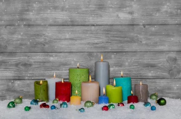 Decorazione natalizia colorata con candele diverse su grigio e — Foto Stock