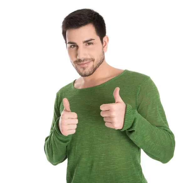 Счастливый одинокий молодой человек в зеленом пуловере делает большой палец вверх gestu — стоковое фото