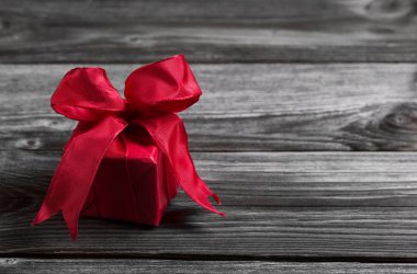 bir kırmızı neşeli Noel hediyesi üzerinde eski püskü ahşap arka plan.