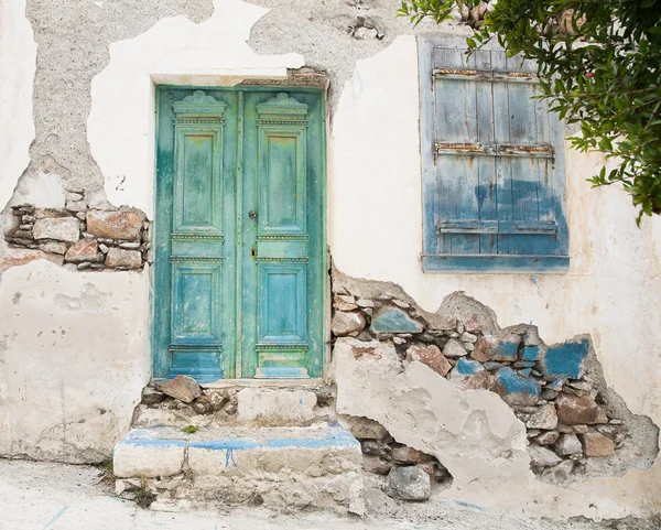 Antigua puerta de madera de una fachada o fachada de una casa asquerosa y demacrada . — Foto de Stock