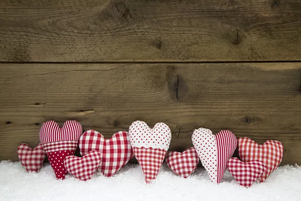 Ručně vyráběné červené bílé zaškrtnutých srdce na dřevěné vánoční poz — Stock fotografie