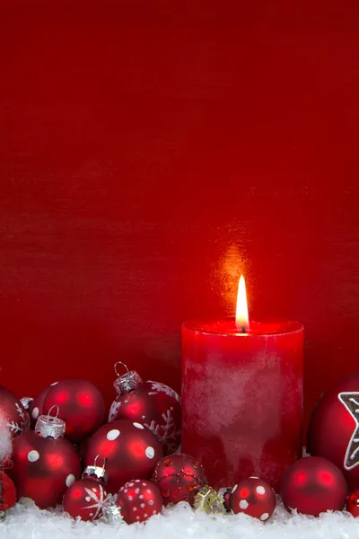 Vela de Natal vermelho com bolas no fundo de madeira . — Fotografia de Stock