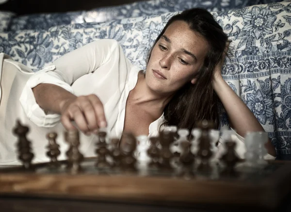 Junge Brünette spielt Schach — Stockfoto