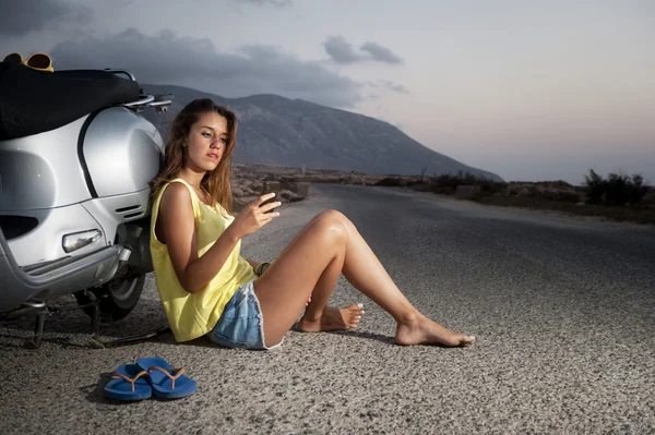 Unga kvinnliga har en motorcykel resa och beundrar utsikten — Stockfoto