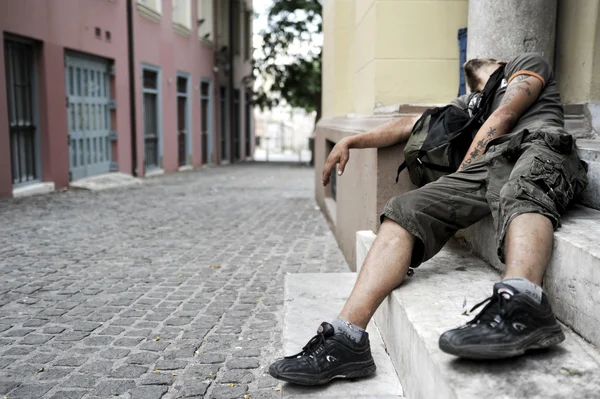 Homem viciado em drogas jaz em uma porta — Fotografia de Stock