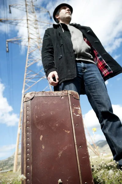 Uomo con valigia in un campo — Foto Stock