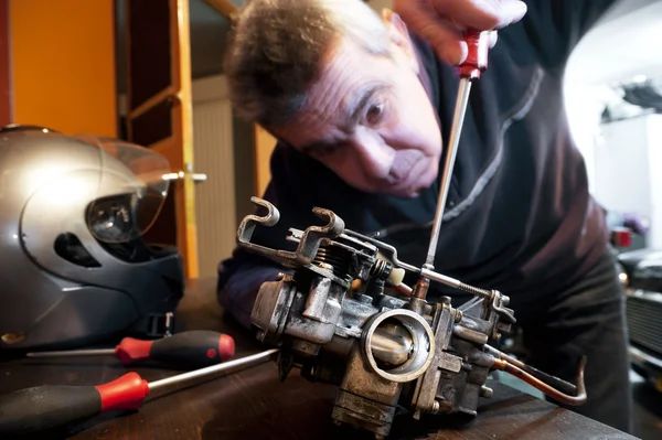 Mecanic repairs a carburetor — Stock Photo, Image