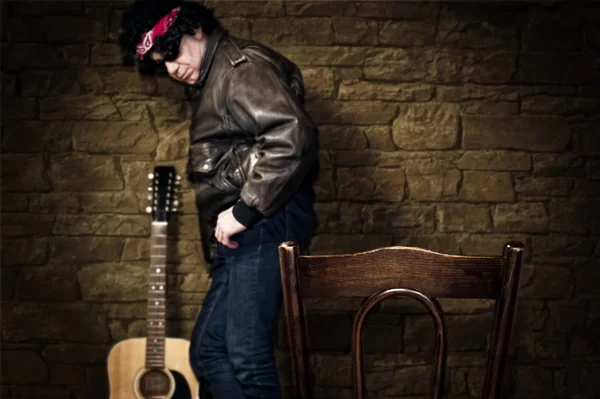 Musician stands against wall in shallow depth of field — Stock Photo, Image