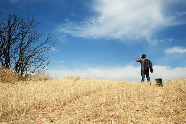 Homem com binóculos em um campo — Fotografia de Stock