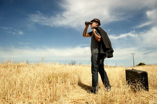 Hombre con prismáticos en un campo — Foto de Stock