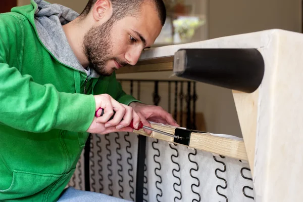 Hombre reparando un sofá — Foto de Stock