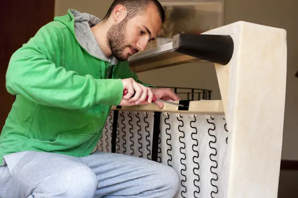 Hombre reparando un sofá — Foto de Stock