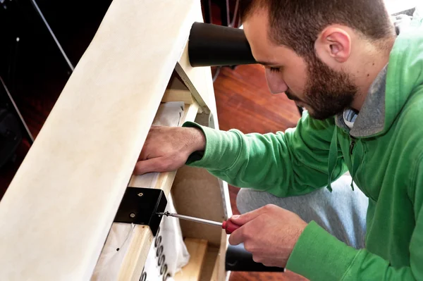 Hombre reparando un sofá — Foto de Stock