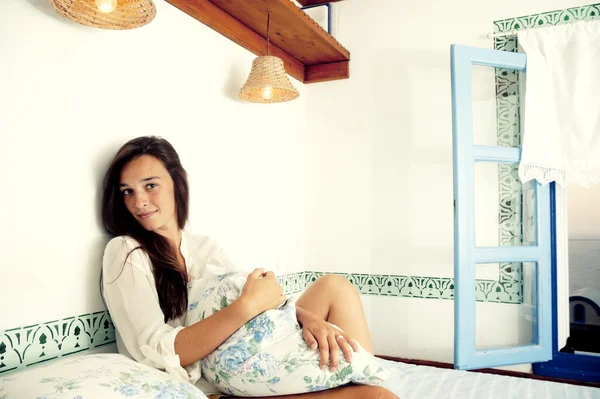 Молодая женщина сидит на кровати — стоковое фото