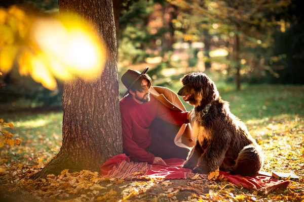 Молодой Человек Темноволосый Красном Свитере Шляпе Лежит Деревом Собакой Второй — стоковое фото