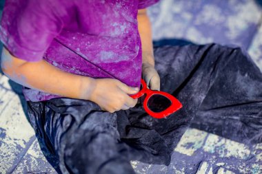 Holi Festivali 'nde mor tişörtlü, leylak boyalı, neşeli bir kız.