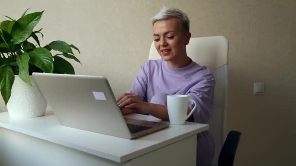 Młoda Piękna Kobieta Blondynka Siedząca Obok Laptopa Fioletowej Piżamie Pisząca — Wideo stockowe