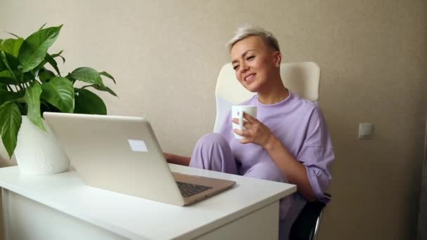 Młoda Piękna Blondynka Siedzi Obok Laptopa Fioletowej Piżamie Trzyma Biały — Wideo stockowe