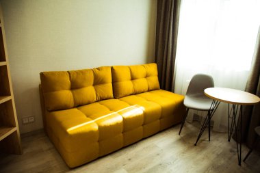 Sarı, yumuşak, modaya uygun bir kanepe otel odasının içinde.