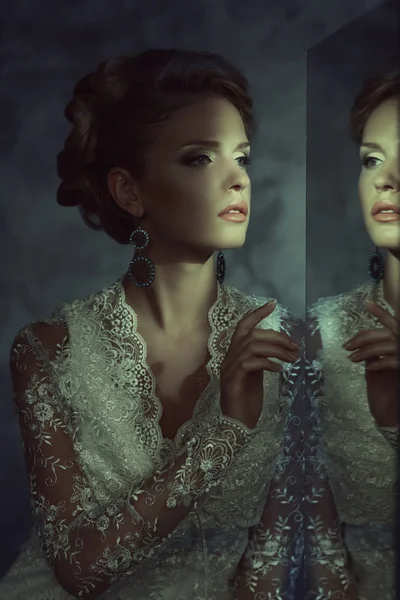 Девушка в свадебном платье возле зеркала — стоковое фото