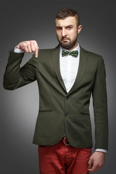 Young man in a green suit, pointing down — Stock Photo, Image