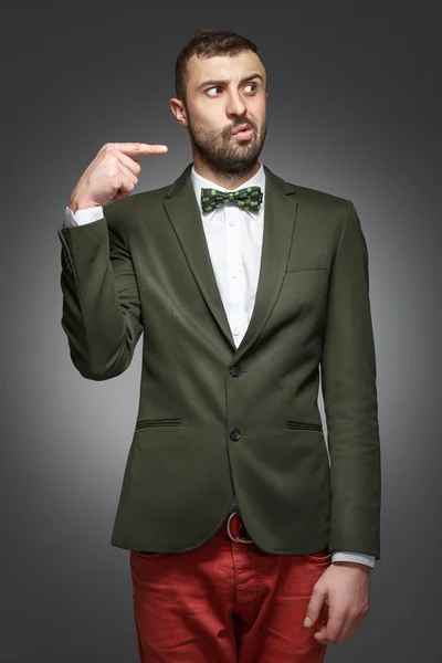 Young man in a green suit, pointing at the right — Stock Photo, Image