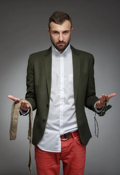 Hombre joven en un traje verde, elegir una corbata o pajarita —  Fotos de Stock