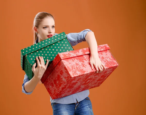 Girl with a gift box on a beige background — Stock Photo, Image