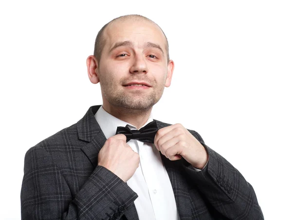 Happy young man adjusts his bow tie — Stock Photo, Image