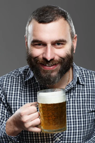 Hombre feliz bebiendo cerveza de la taza — Foto de Stock