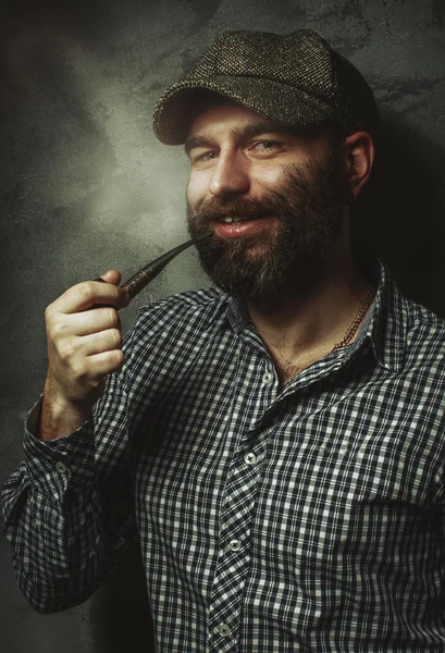 Portret van jonge stijlvolle man met een baard met een pijp — Stockfoto