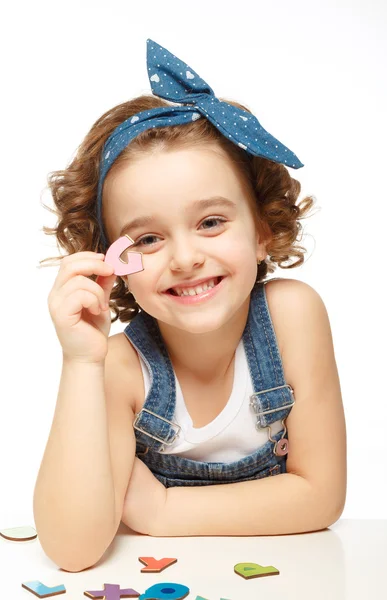 Little girl playing in the alphabet. Shows the letter G. — Stock Photo, Image