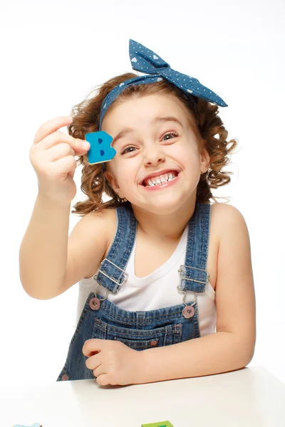 Uma menina a brincar no alfabeto. Mostra a letra B . — Fotografia de Stock