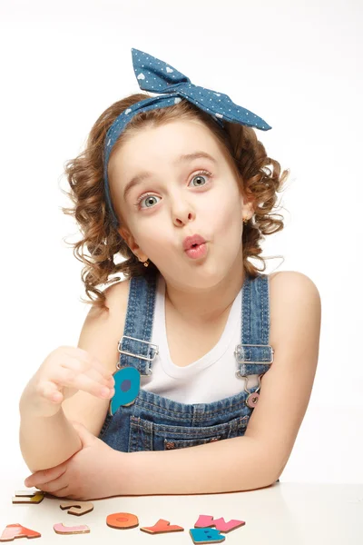 Little girl playing in the alphabet. Shows the letter Q. — Stock Photo, Image