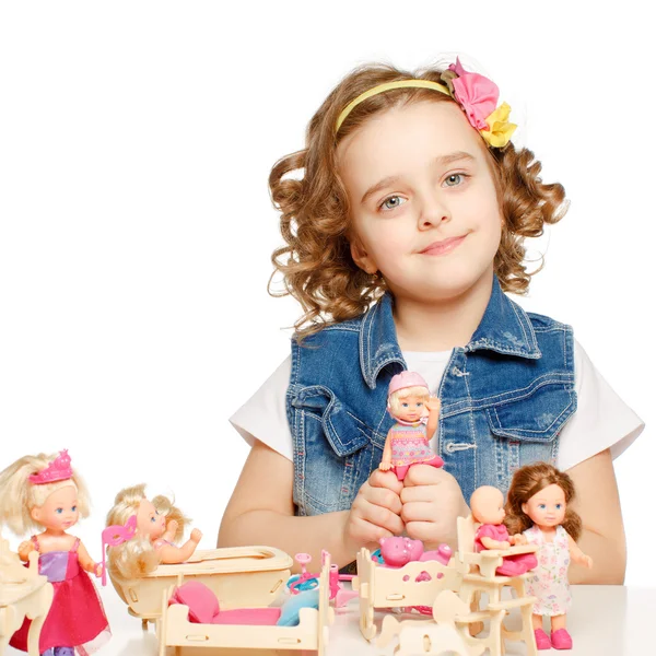 Malá dívka si hraje s panenkami. — Stock fotografie