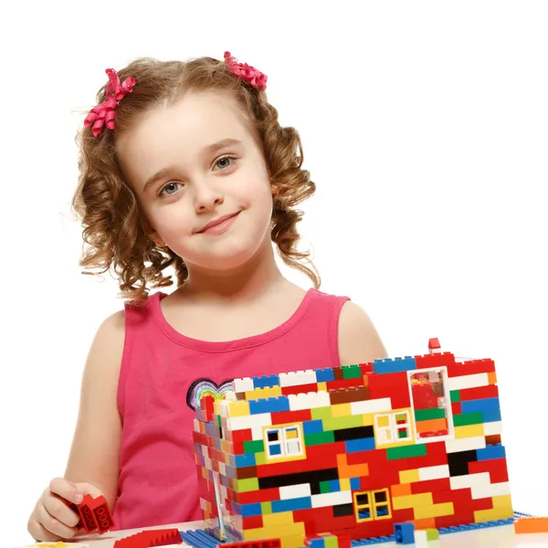 Small girl builds a house from plastic blocks Royalty Free Stock Images