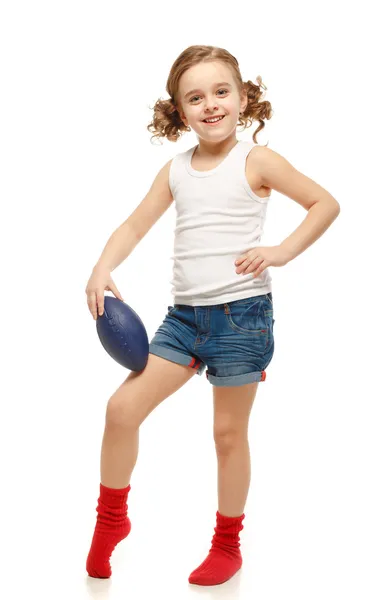 En liten flicka med rugbyboll. — Stockfoto