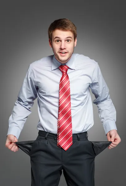 Hombre de negocios mostrando su bolsillo vacío, girando su bolsillo dentro — Foto de Stock