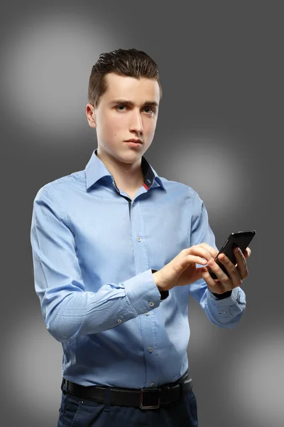 Young businessman dials number on cellular phone — Stock Photo, Image