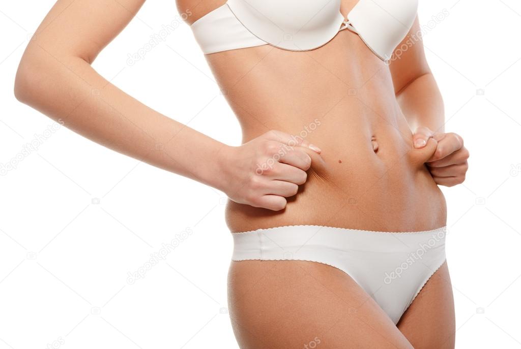 Teenage girl checks excess weight in their abdomen.
