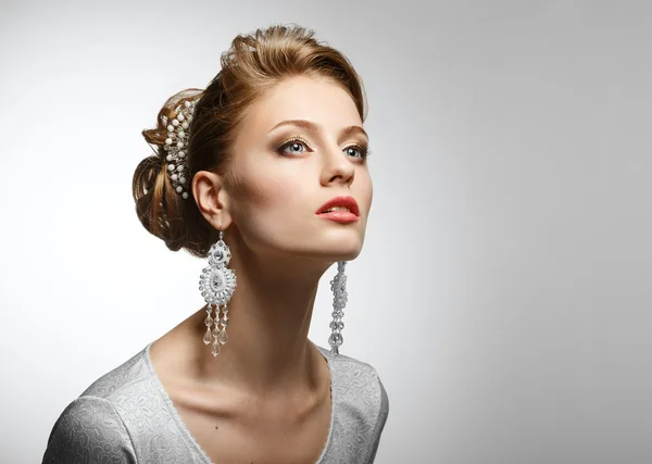 Portrait of a beautiful girl in a white dress and big earrings. — Stock Photo, Image