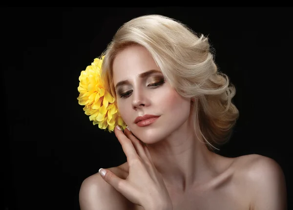 Krásná mladá blondýnka na černém pozadí s žlutá — Stock fotografie