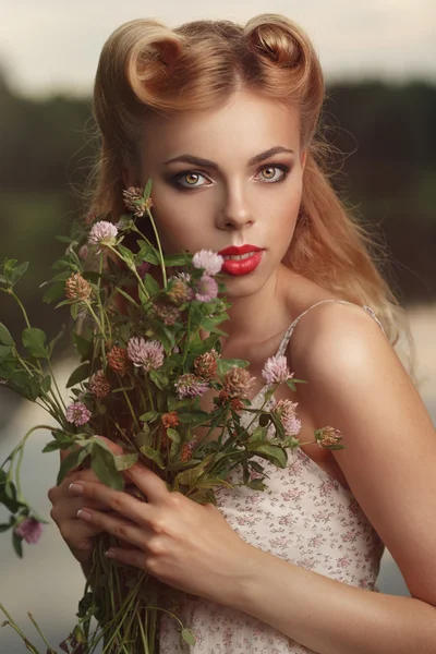 Portrait of a girl with a bouquet of clover at sunset. — Stock Photo, Image