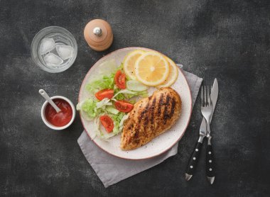 Fried chicken breast. Grilled chicken breast with vegetable salad and lemon. Top view, flat lay.