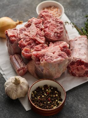 Ingredients for Southern Smothered Oxtails: Raw beef oxtail, onion, garlic, and other ingredients used to make braised oxtails and gravy