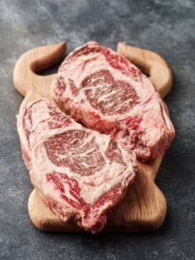 Raw entrecote on a wooden board. Fresh marbled beef.